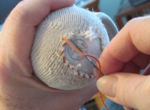 light bulb, darning a sock, sock, darning needle, repairing hole in sock,